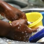 Mulher lavando louça e realizando atividades domésticas - Foto: Reprodução/Freepik