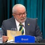 Luiz Inácio Lula da Silva enquanto discursa, sentado em mesa durante evento oficial | Reprodução: Ricardo Stuckert