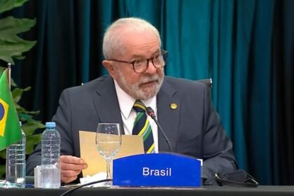 Luiz Inácio Lula da Silva enquanto discursa, sentado em mesa durante evento oficial | Reprodução: Ricardo Stuckert