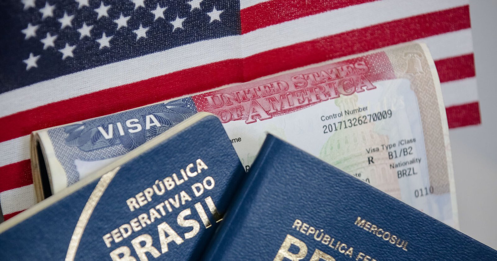 Passaporte brasileiro com fundo dos Estados Unidos e visto americano.