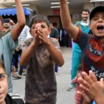 Crianças palestinas celebram anúncio de cessar-fogo em Deir al-Balah, centro de Gaza.