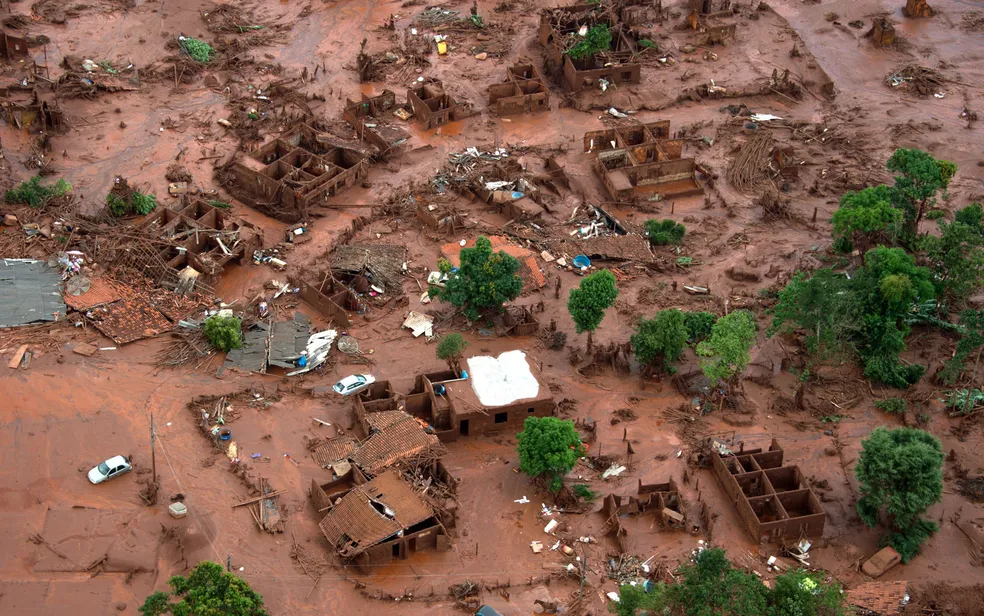 Carros e destroços de casas eram vistos em meio à lama após o rompimento da barragem de Fundão em Bento Rodrigues, em Mariana -Foto: Christophe Simon/AFP