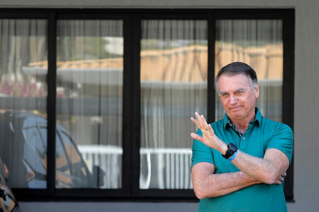 Pena: Jair Bolsonaro acena na garagem de casa, em Brasília - Foto: Sergio Lima/AFP