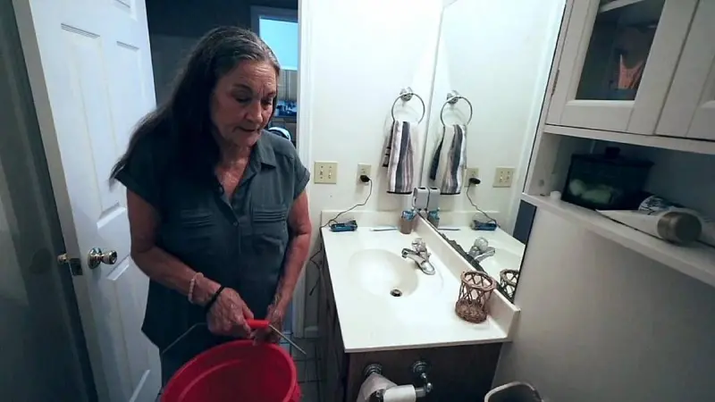 Beverly Morris precisa encher baldes para usar o banheiro devido à baixa pressão da água - Foto: BBC