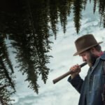 Pôster oficial de 'Sonhos de Trem', drama contemplativo dirigido por Clint Bentley e estrelado por Joel Edgerton, que transforma a passagem do tempo em paisagem e memória - Foto: Divulgação/Netflix