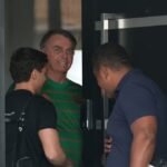 O ex-presidente do Brasil, Jair Bolsonaro, aparece na porta de sua casa, durante sua prisão domiciliar, em Brasília, Brasil, em 21 de novembro - Foto: Mateus Bonomi/Reuters