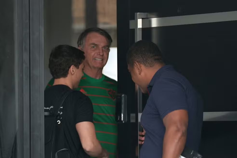 O ex-presidente do Brasil, Jair Bolsonaro, aparece na porta de sua casa, durante sua prisão domiciliar, em Brasília, Brasil, em 21 de novembro - Foto: Mateus Bonomi/Reuters