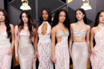 Foto das integrantes do Katseye posando em red carpet da edição de 2026 do Grammy. Todas as seis vestem vestidos brancos.