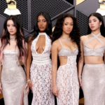 Foto das integrantes do Katseye posando em red carpet da edição de 2026 do Grammy. Todas as seis vestem vestidos brancos.