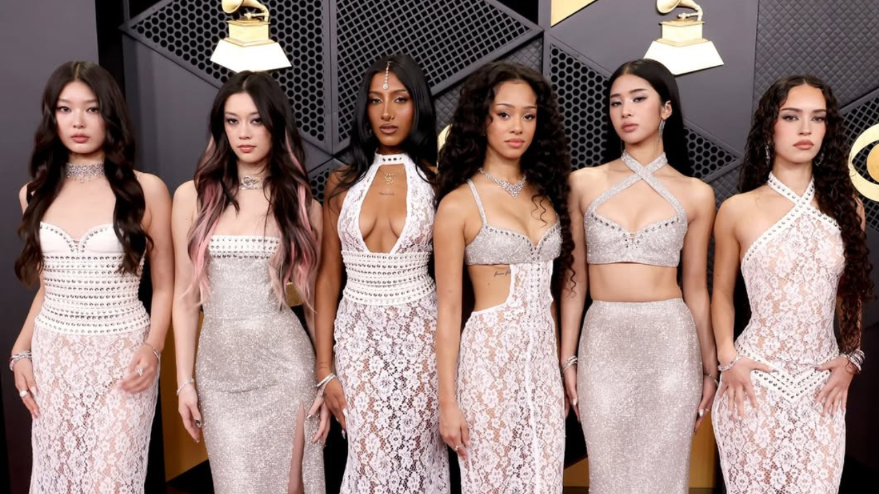 Foto das integrantes do Katseye posando em red carpet da edição de 2026 do Grammy. Todas as seis vestem vestidos brancos.