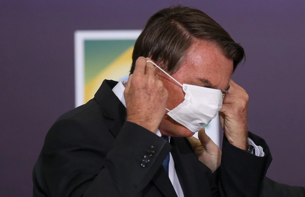 Jair Bolsonaro se atrapalha com máscara de proteção durante entrevista sobre medidas para conter a pandemia de covid-19, em março de 2020 - Foto: Pedro Ladeira/Folhapress